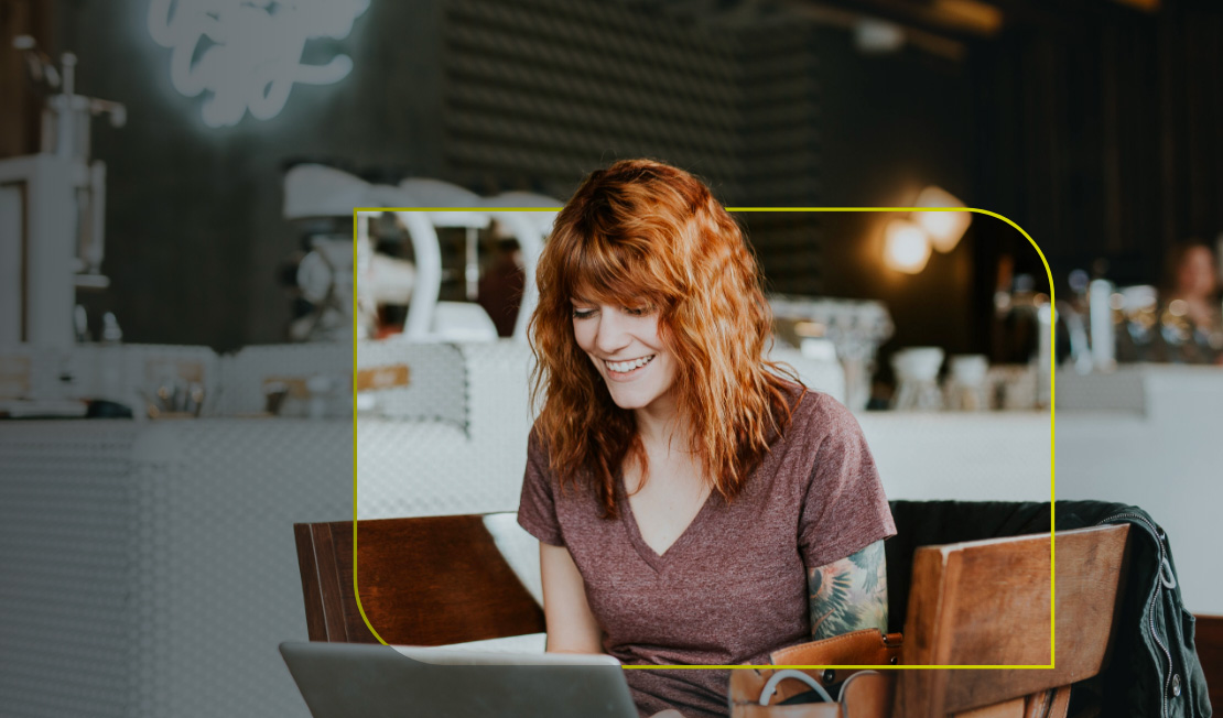 A woman working at her laptop in a cafe